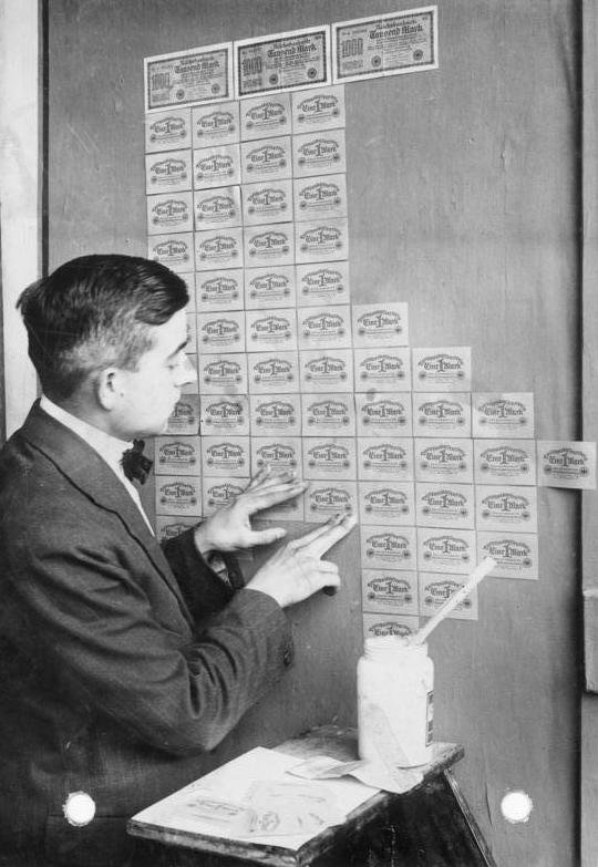 Hiperinflacja w Niemczech, 1923: ściany tapetowano banknotami marek, bo papier pieniądza stał się tańszy niż tapeta — skrajny obraz spadku siły nabywczej. · źródło: Georg Pahl, Bundesarchiv, Wikimedia Commons, CC BY-SA 3.0 DE