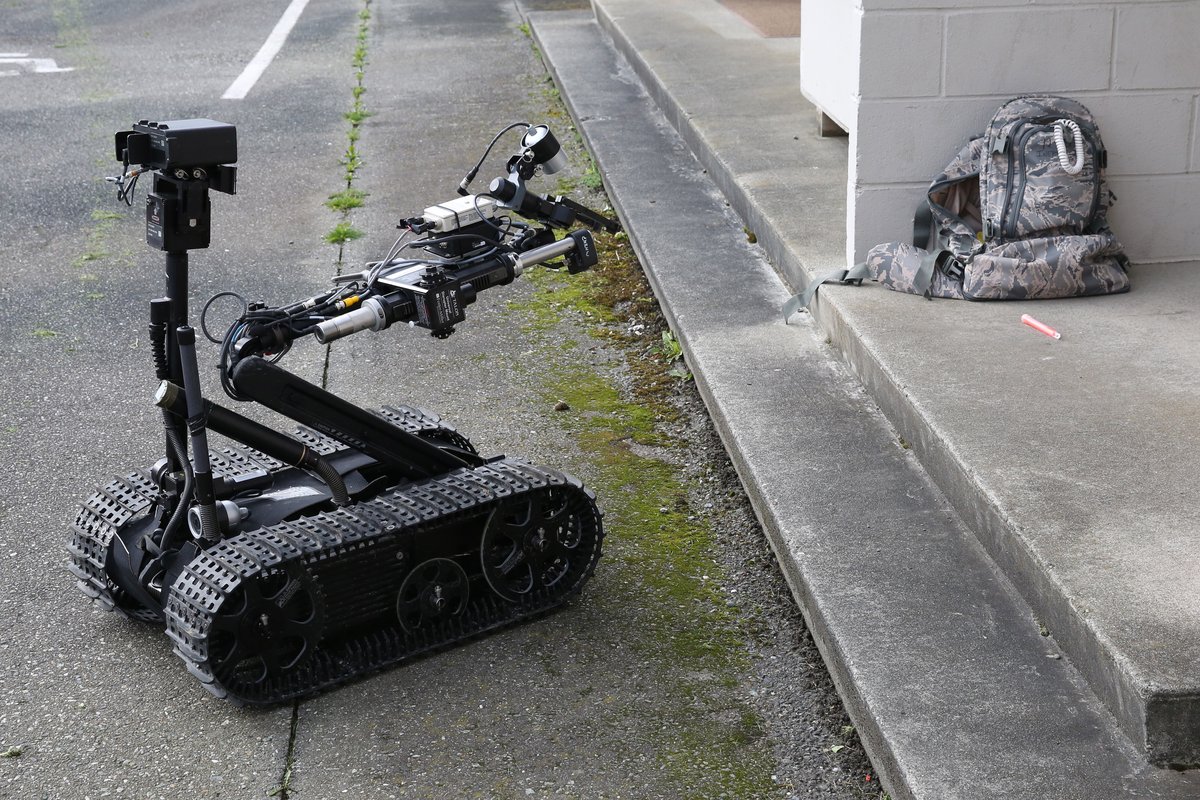 Robot pirotechniczny (saper) sprawdza podejrzany pakunek podczas ćwiczeń antyterrorystycznych. Improwizowany ładunek wybuchowy (IED) rozbrajają specjaliści — nigdy nie wolno dotykać podejrzanych przedmiotów. · źródło: US Navy, Wikimedia Commons, domena publiczna