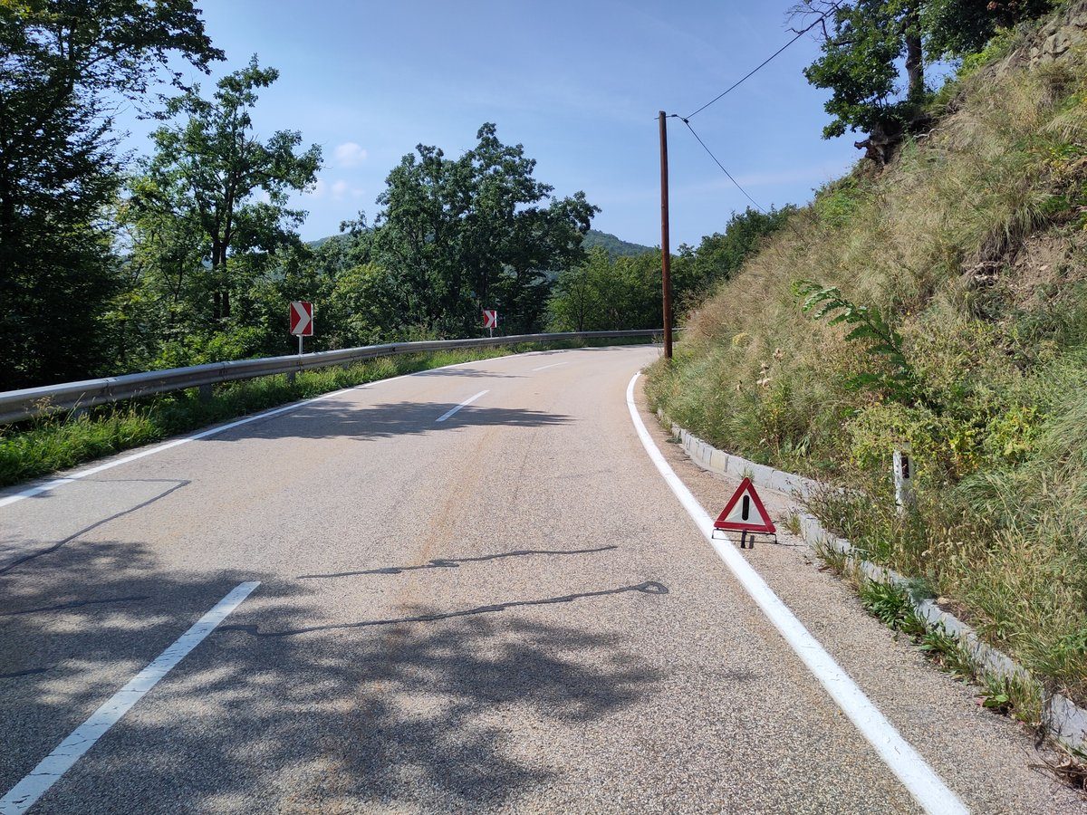 Trójkąt ostrzegawczy ustawiony na drodze. Zabezpieczenie miejsca wypadku (trójkąt, kamizelka odblaskowa, wyłączenie zapłonu) zmniejsza ryzyko kolejnych zdarzeń. · źródło: Jaller94, Wikimedia Commons, CC0