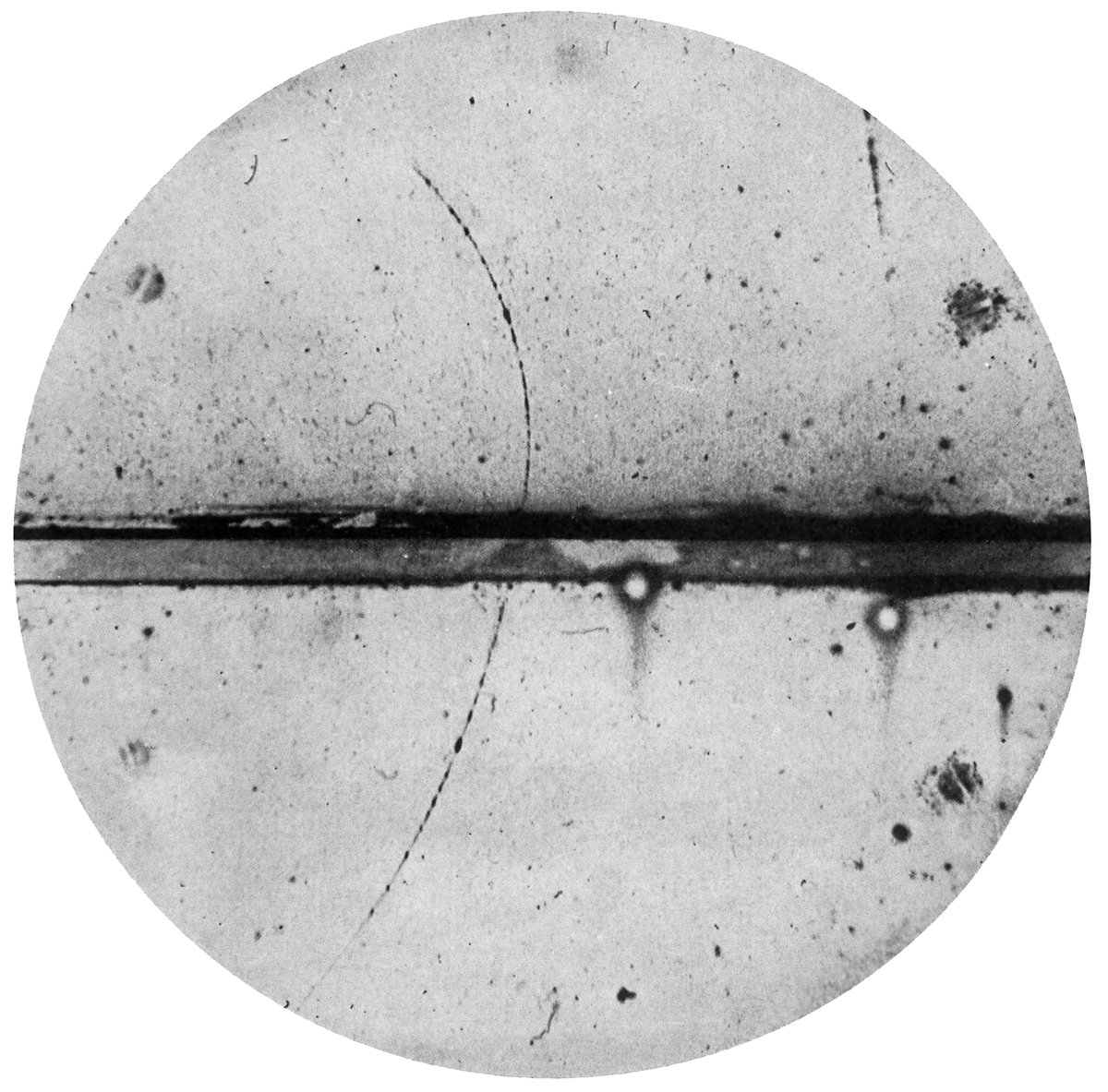 Pierwsze zdjęcie pozytonu (antymaterii) w komorze Wilsona, Carl Anderson 1932: zakrzywiony tor cząstki o ładunku dodatnim potwierdził istnienie antycząstki elektronu. · źródło: Carl D. Anderson, Wikimedia Commons, domena publiczna