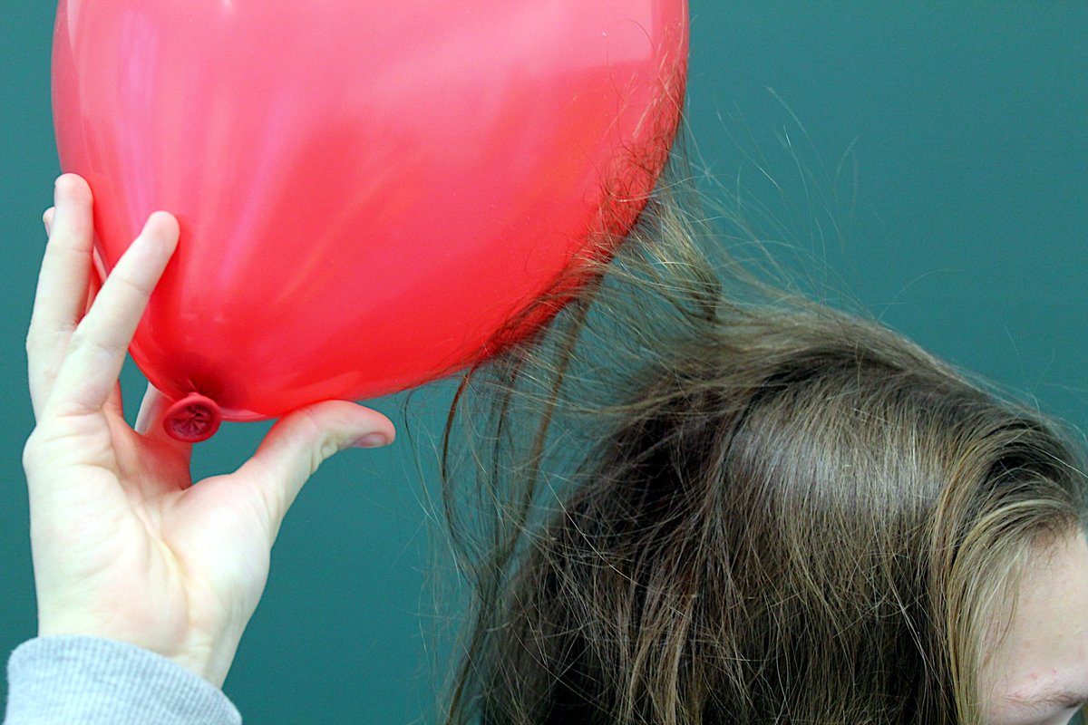 Elektryzowanie przez tarcie — naelektryzowany balon przyciąga włosy siłą elektrostatyczną. · źródło: MikeRun, Wikimedia Commons, CC BY-SA 4.0