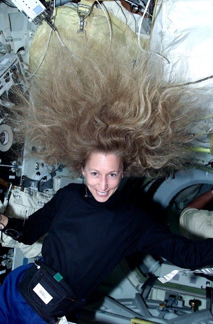 Stan nieważkości na orbicie — swobodnie unoszące się włosy astronautki pokazują, że stacja i jej załoga spadają swobodnie wokół Ziemi. · źródło: NASA, Wikimedia Commons, domena publiczna