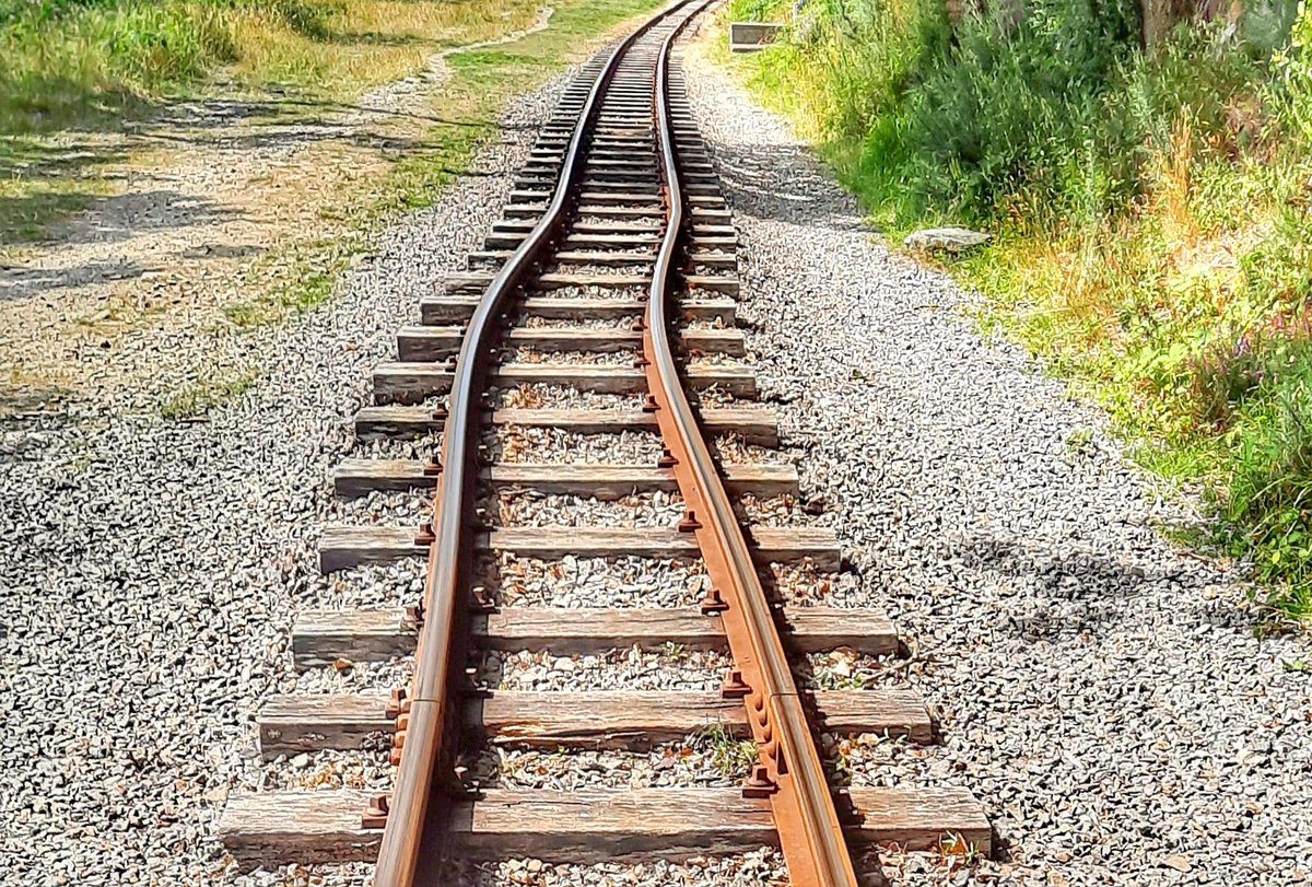 Tory kolejowe wygięte podczas fali upałów — szyny wydłużają się od ciepła i jeśli nie mają gdzie się rozszerzyć, wyboczają się. · źródło: Hefin Owen, Wikimedia Commons, CC BY-SA 2.0