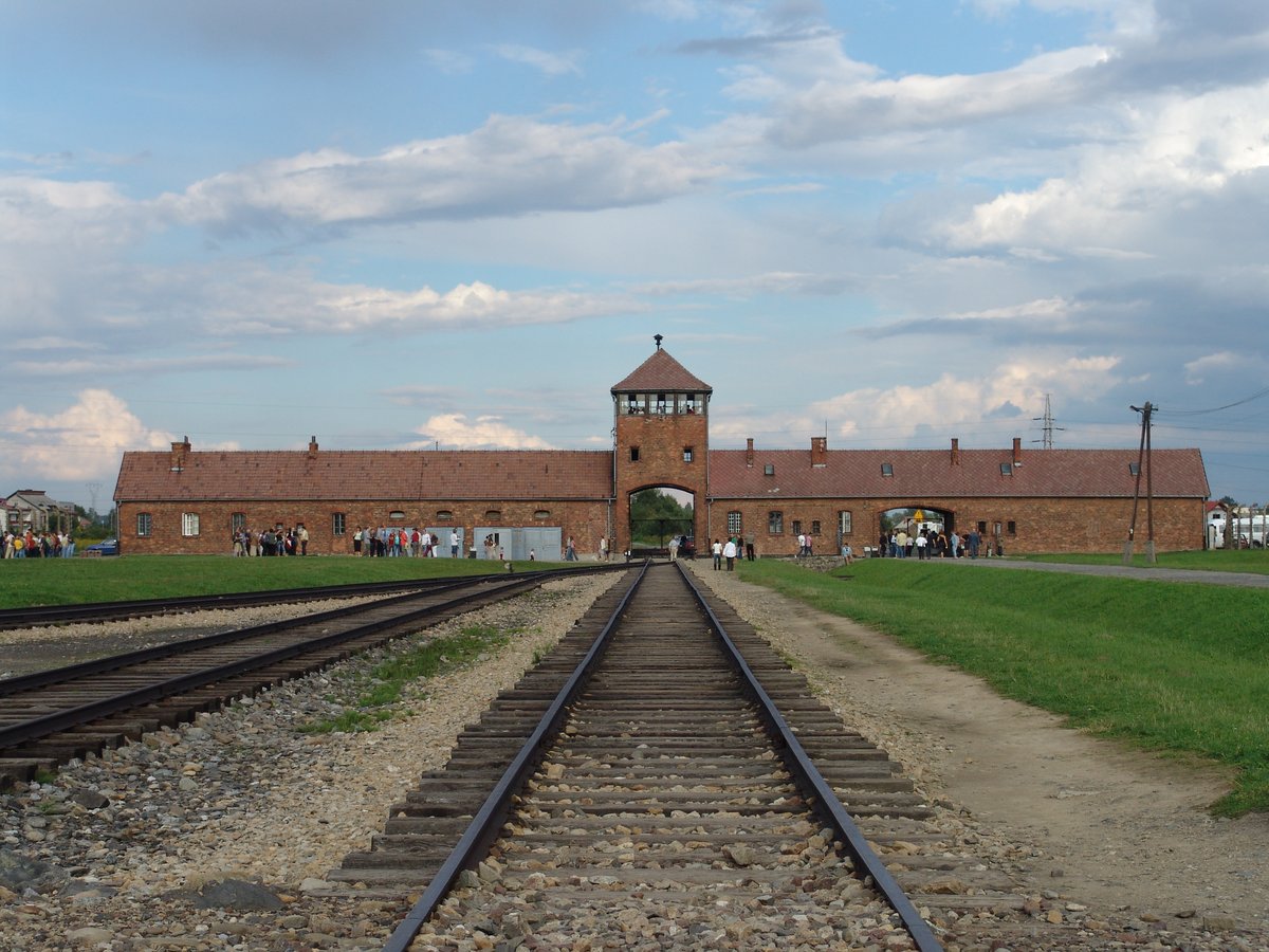 Brama obozu Auschwitz-Birkenau z rampą kolejową. KL Auschwitz stał się symbolem Holokaustu — zagłady około sześciu milionów Żydów. · źródło: Michel Zacharz, Wikimedia Commons, CC BY-SA 2.5