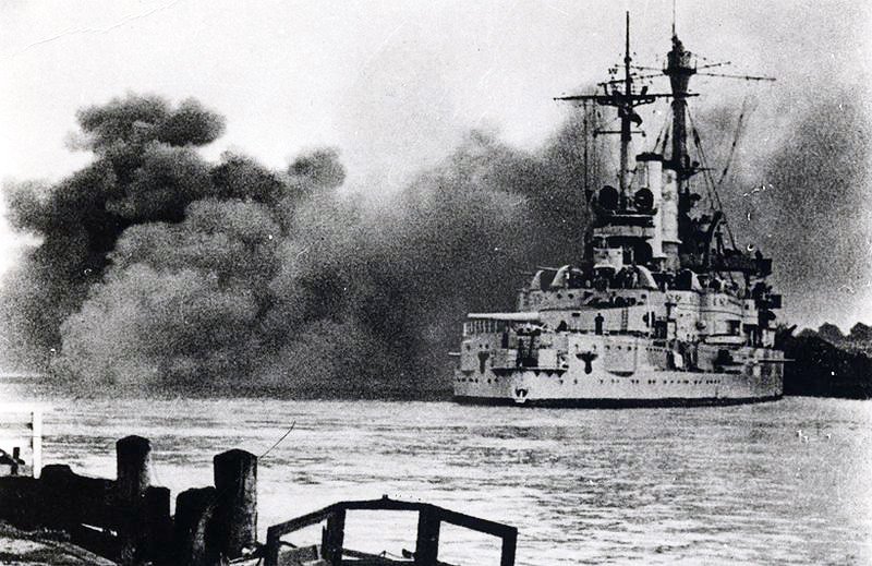 Pancernik „Schleswig-Holstein” ostrzeliwuje Westerplatte, 1 września 1939. Te salwy rozpoczęły II wojnę światową; załoga Westerplatte broniła się przez 7 dni. · źródło: nieznany, Wikimedia Commons, domena publiczna