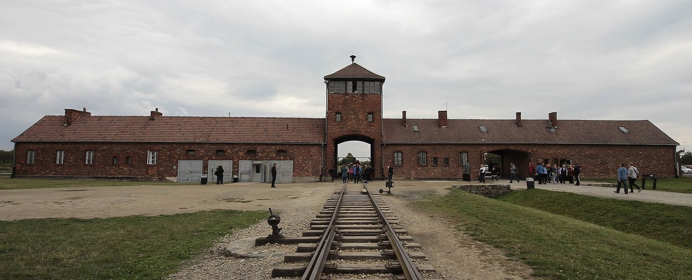 Auschwitz II-Birkenau — brama główna z torami (UNESCO 1979) — obóz zagłady jako pomnik ofiar Holokaustu; wpisany jako przestroga, nie zabytek piękna · źródło: fot. Oleg Yunakov, Wikimedia Commons, CC BY-SA 4.0