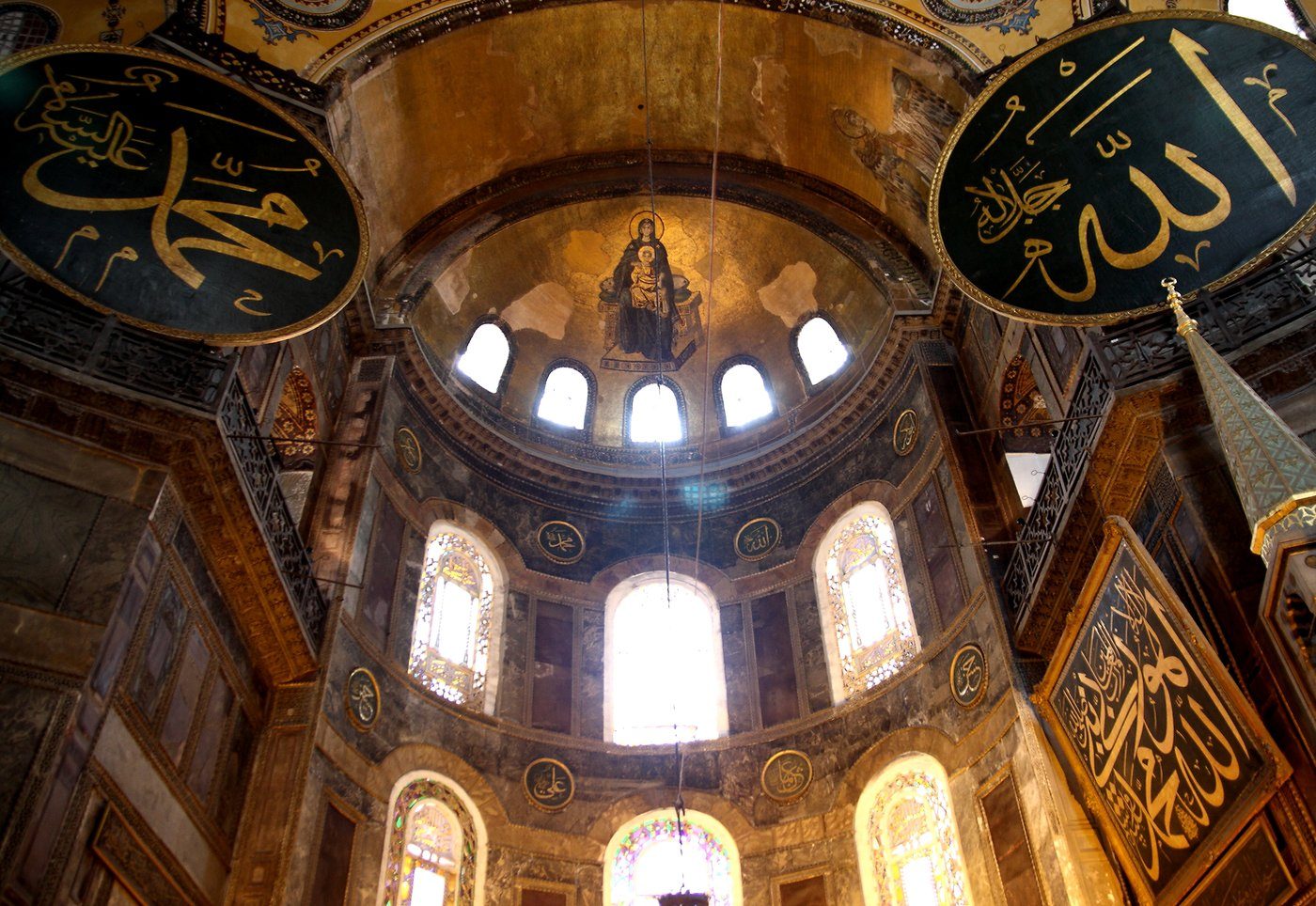 Wnętrze Hagia Sophia (532–537, Konstantynopol) — apsyda z mozaiką Marii z Dzieciątkiem (867 r.) i osmańskie tarcze z imionami Allaha i Mahometa; świątynia była kolejno kościołem, meczetem i muzeum · źródło: Altay Ozcan, Wikimedia Commons, CC BY-SA 4.0