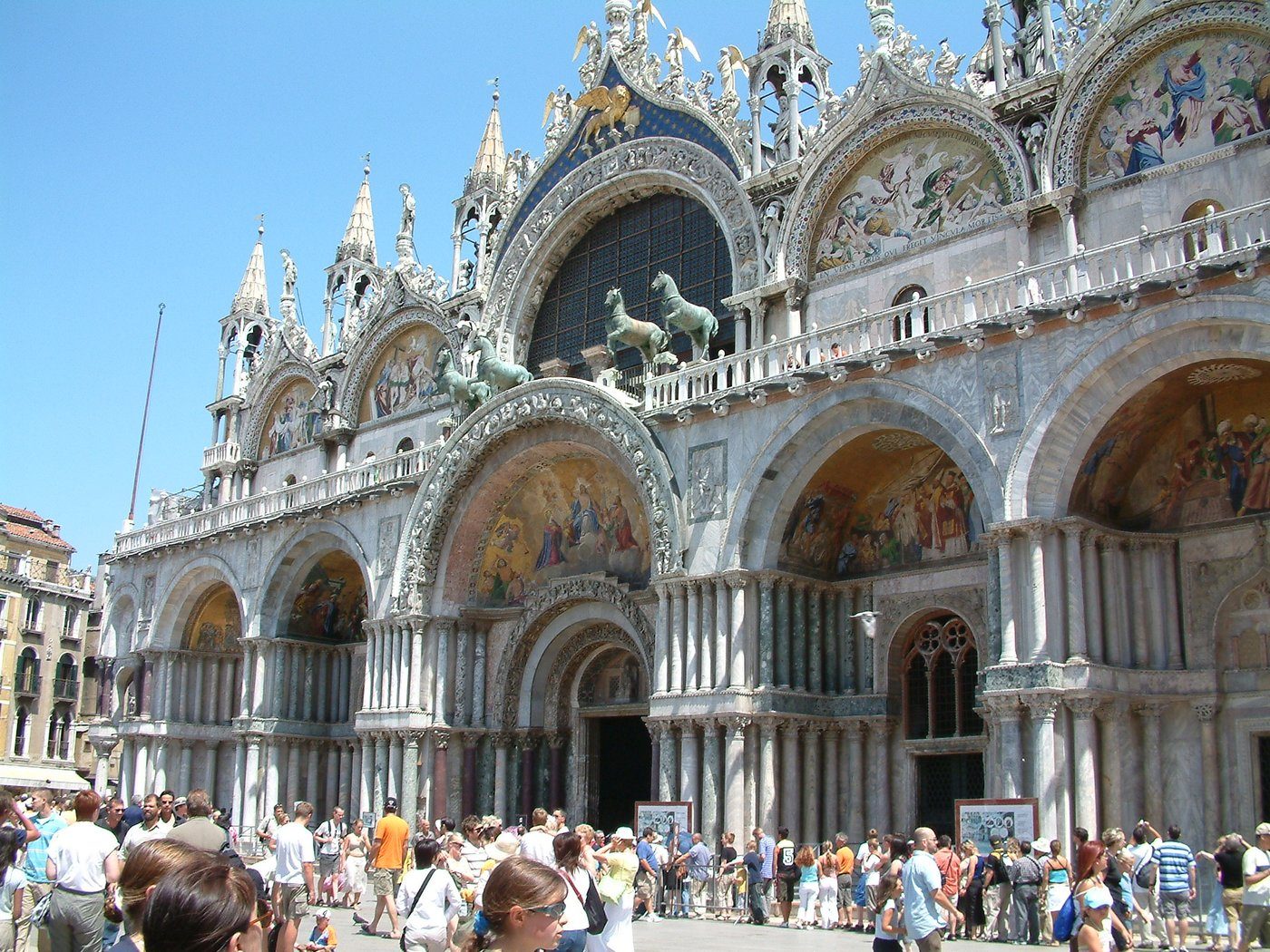 Bazylika San Marco w Wenecji (przebudowana po 1063) — plan krzyża greckiego z pięcioma kopułami, fasada z mozaikami i końmi św. Marka; architektura wprost bizantyjska · źródło: Maria Schnitzmeier, Wikimedia Commons, CC BY-SA 3.0