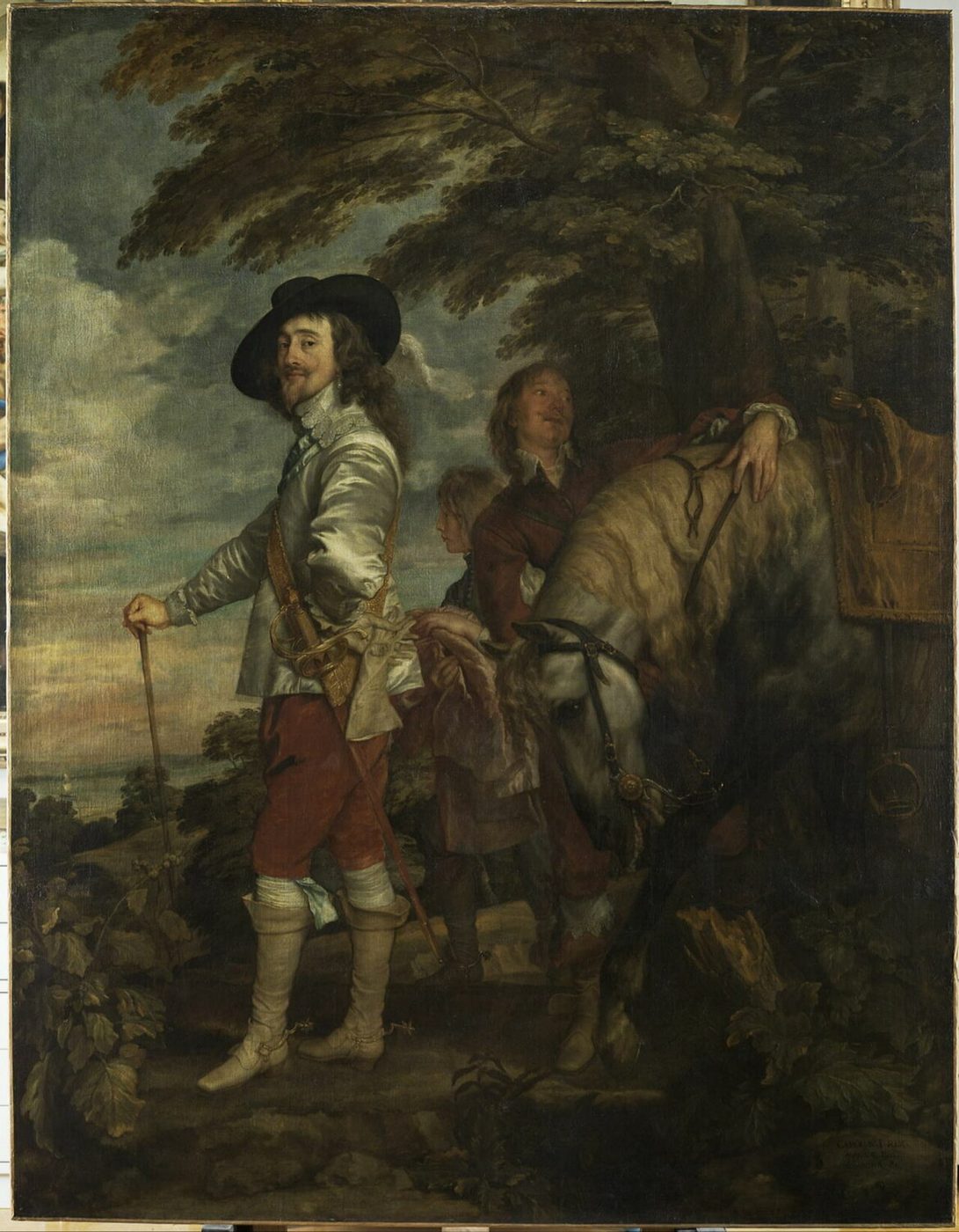 Anton van Dyck, Karol I na polowaniu (ok. 1635, Luwr) — król w stroju myśliwego i w kapeluszu, wsparty na lasce, obok koń i służba; władza pokazana swobodą, a nie koroną · źródło: Wikimedia Commons, domena publiczna