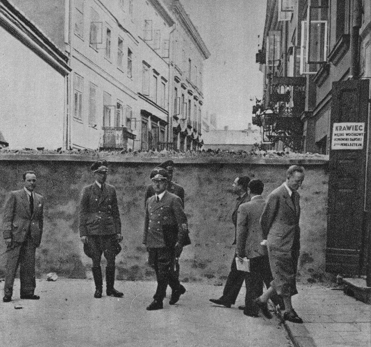 Niemieccy urzędnicy przy murze getta warszawskiego, 1941 — mur odgradzał dzielnicę zamkniętą od reszty miasta. · źródło: nieznany autor, Wikimedia Commons, domena publiczna
