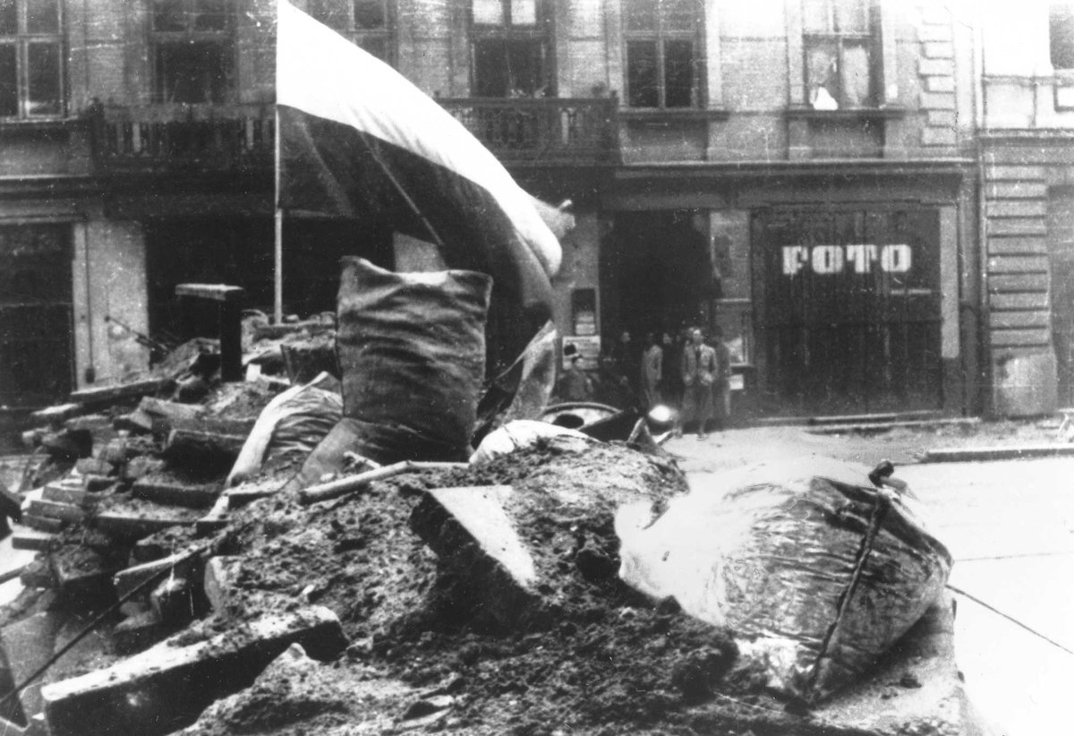 Barykada z polską flagą podczas powstania warszawskiego 1944 — doświadczenie pokolenia, z którego wyrasta poezja Baczyńskiego. · źródło: nieznany autor, Wikimedia Commons, domena publiczna