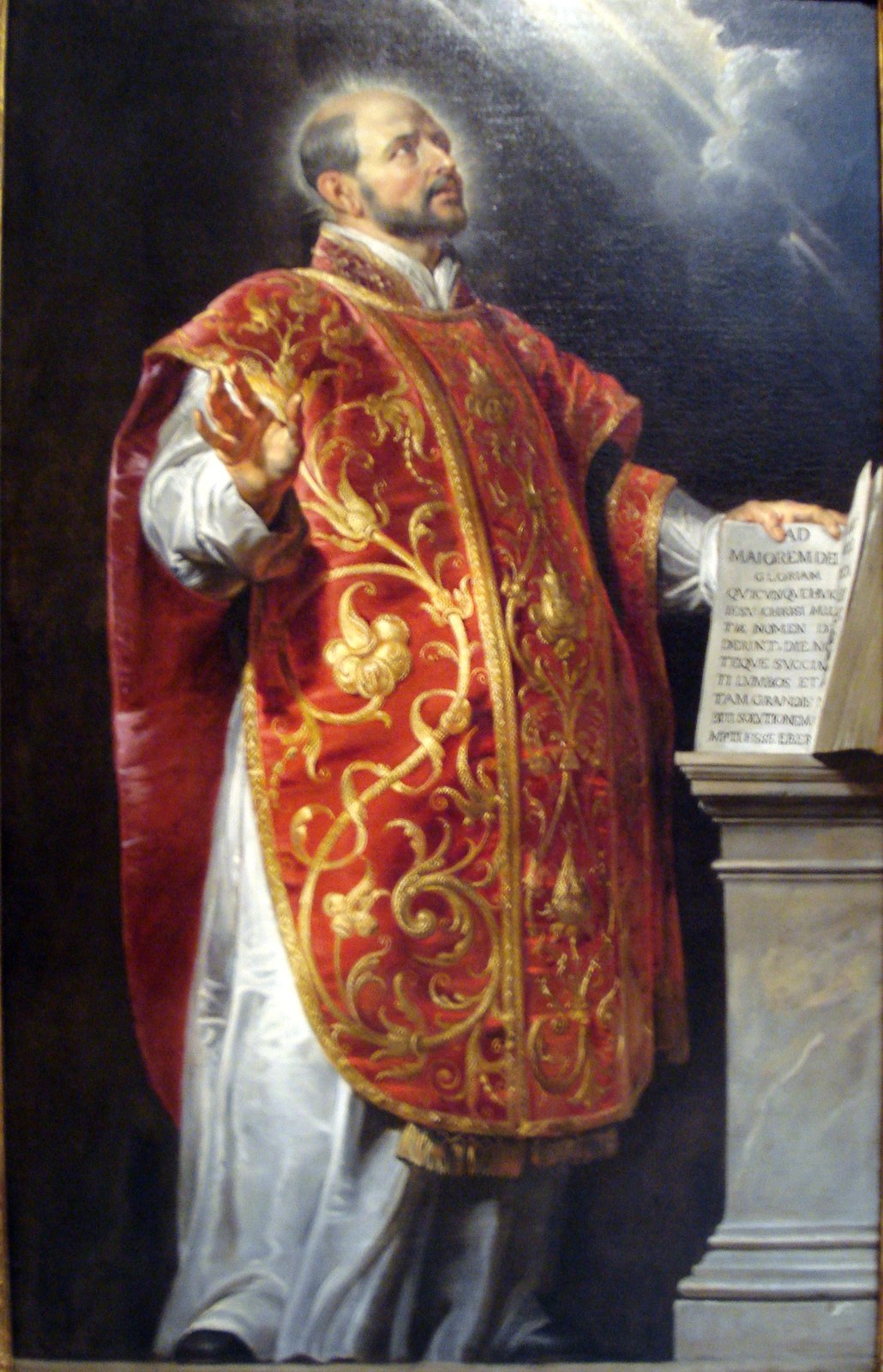 Św. Ignacy Loyola — obraz Petera Paula Rubensa (ok. 1620): Ignacy w ornacie przy księdze z dewizą „Ad maiorem Dei gloriam” · źródło: Wikimedia Commons, domena publiczna