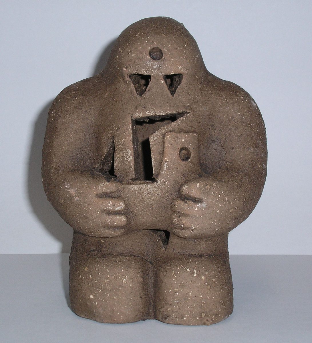 Gliniana figura golema — reprodukcja golema praskiego; przysadzista postać z otwartymi ustami trzyma w dłoniach tabliczkę · źródło: Wikimedia Commons, domena publiczna