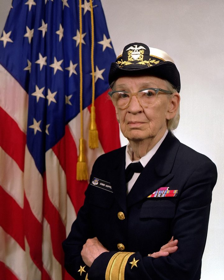 Grace Hopper (1906–1992) — autorka pierwszego kompilatora i współtwórczyni języka COBOL. To po jej pracach programista mógł pisać słowami zbliżonymi do angielskiego, a tłumaczeniem na język maszynowy zajęła się maszyna · źródło: fot. James S. Davis, U.S. Navy, Wikimedia Commons, domena publiczna