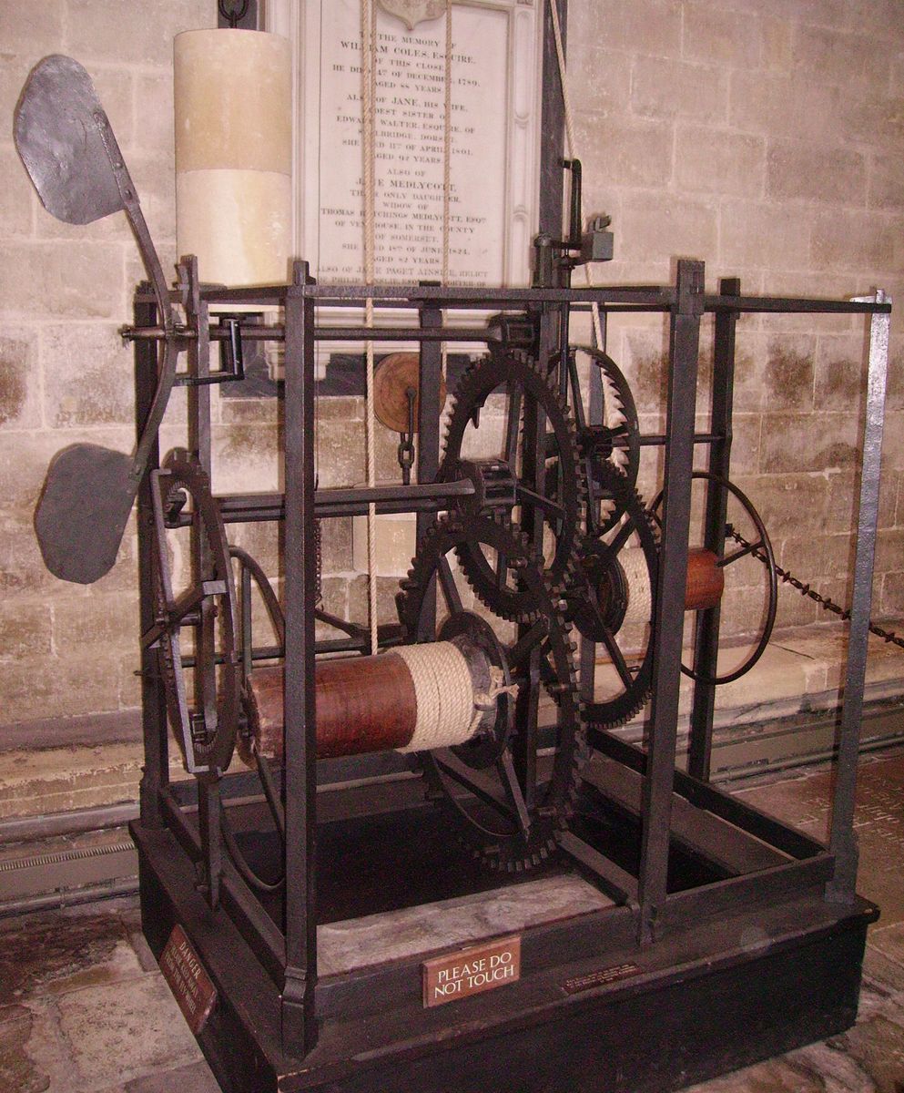 Zegar katedry w Salisbury (ok. 1386) — jeden z najstarszych zachowanych zegarów mechanicznych: żelazna rama, koła zębate, bębny z linami ciężarków i wahadło z dwiema łopatkami; nie ma tarczy ani wskazówek — odmierzał czas biciem w dzwon · źródło: Wikimedia Commons, domena publiczna