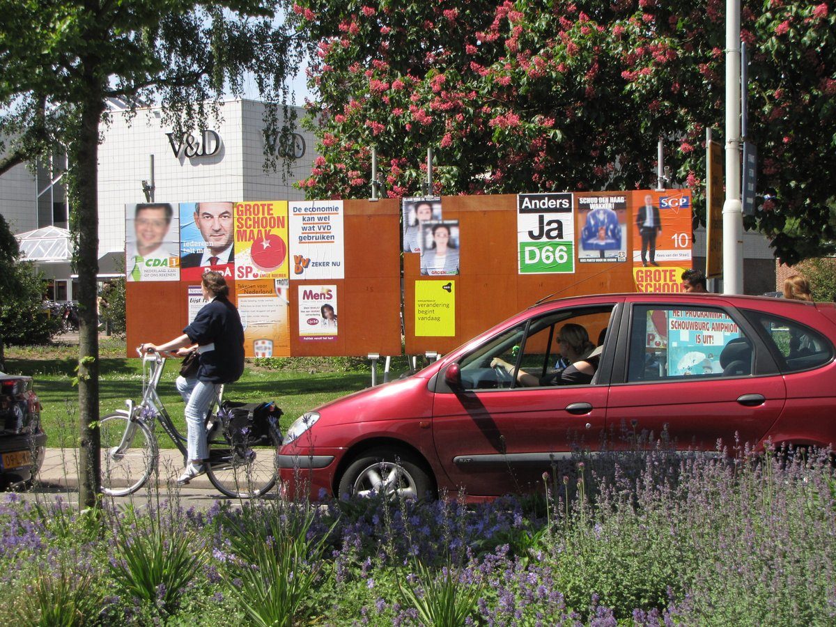 Plakaty wyborcze wielu partii (wybory 2010): jedną z funkcji partii jest kształtowanie opinii i rywalizacja o głosy — pluralizm partyjny w pigułce. · źródło: Ziko, Wikimedia Commons, CC BY-SA 3.0